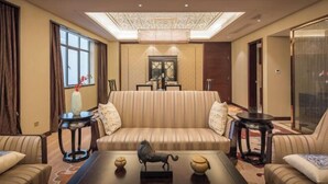 Un salón luminoso con un sofá, dos mesitas auxiliares y elementos decorativos.