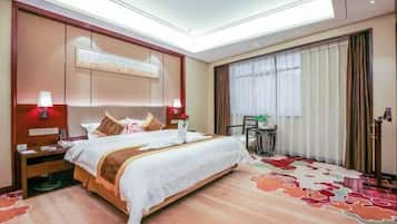 A hotel room with a large bed, bedside lamps, a desk, and a view of the outdoors through the window.