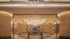 A lobby with a modern design, featuring a central seating area, a decorative wall, and a chandelier. - Liuyiju International Hotel Yongfeng (Yongfeng)