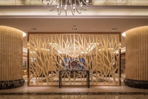 A lobby with a modern design, featuring a central seating area, a decorative wall, and a chandelier. - Liuyiju International Hotel Yongfeng (Yongfeng)