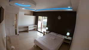 Ein modernes Schlafzimmer mit einem Bett, Nachttischen, einem Deckenventilator und einem großen Fenster.