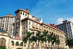 A multi-story hotel with a classical architectural style, featuring balconies and arched windows. - Shengzhan Hotel (Chongzuo)