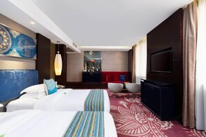 A hotel room with two beds, a TV, a minibar, and a red sofa. - Shengzhan Hotel (Chongzuo)