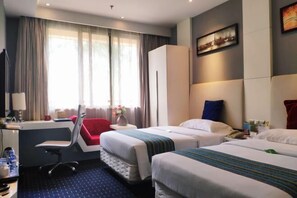 A hotel room with two beds, a desk, a chair, and a large window with curtains. - Shengzhan Hotel (Chongzuo)