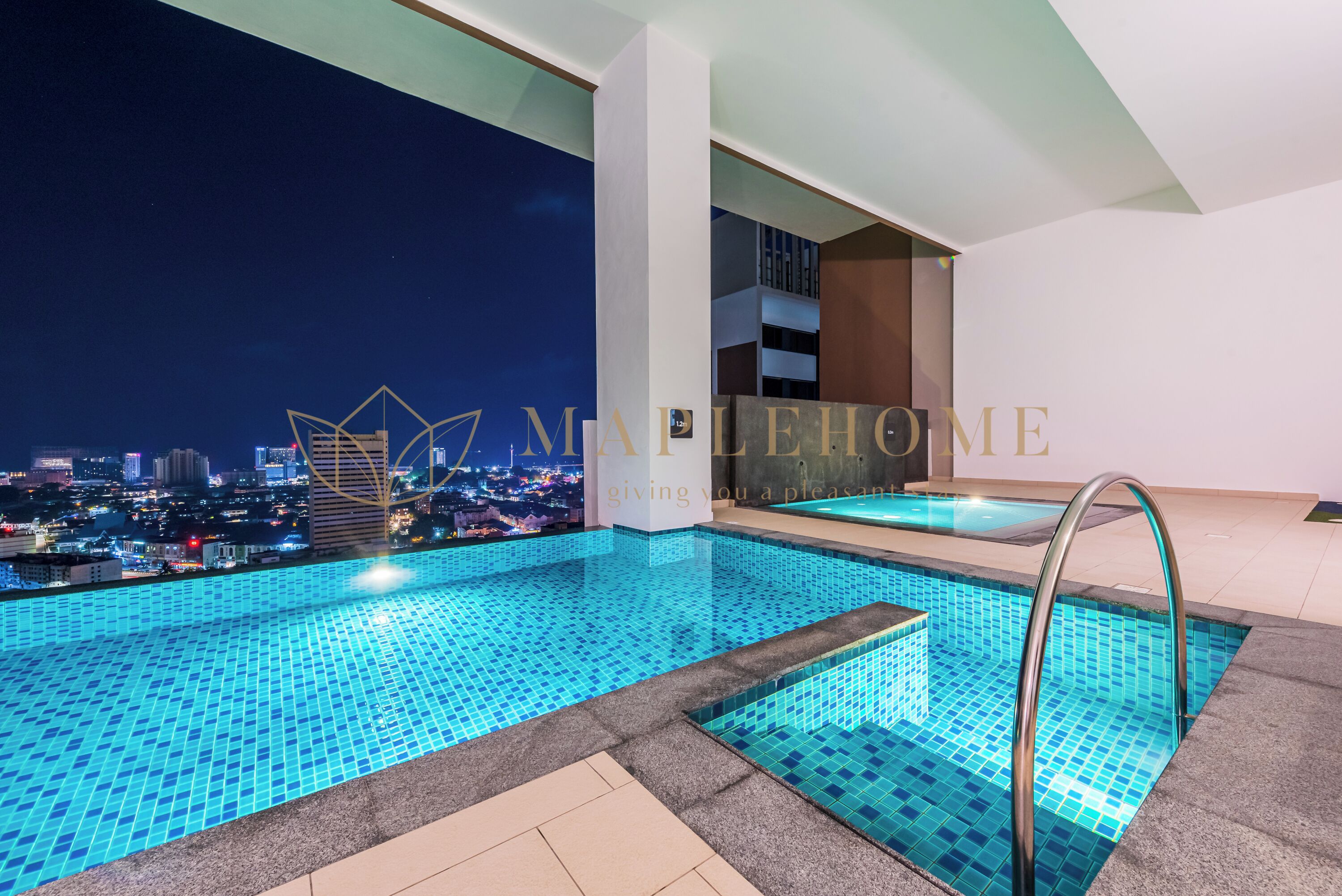 A rooftop infinity pool with a city view at night.
