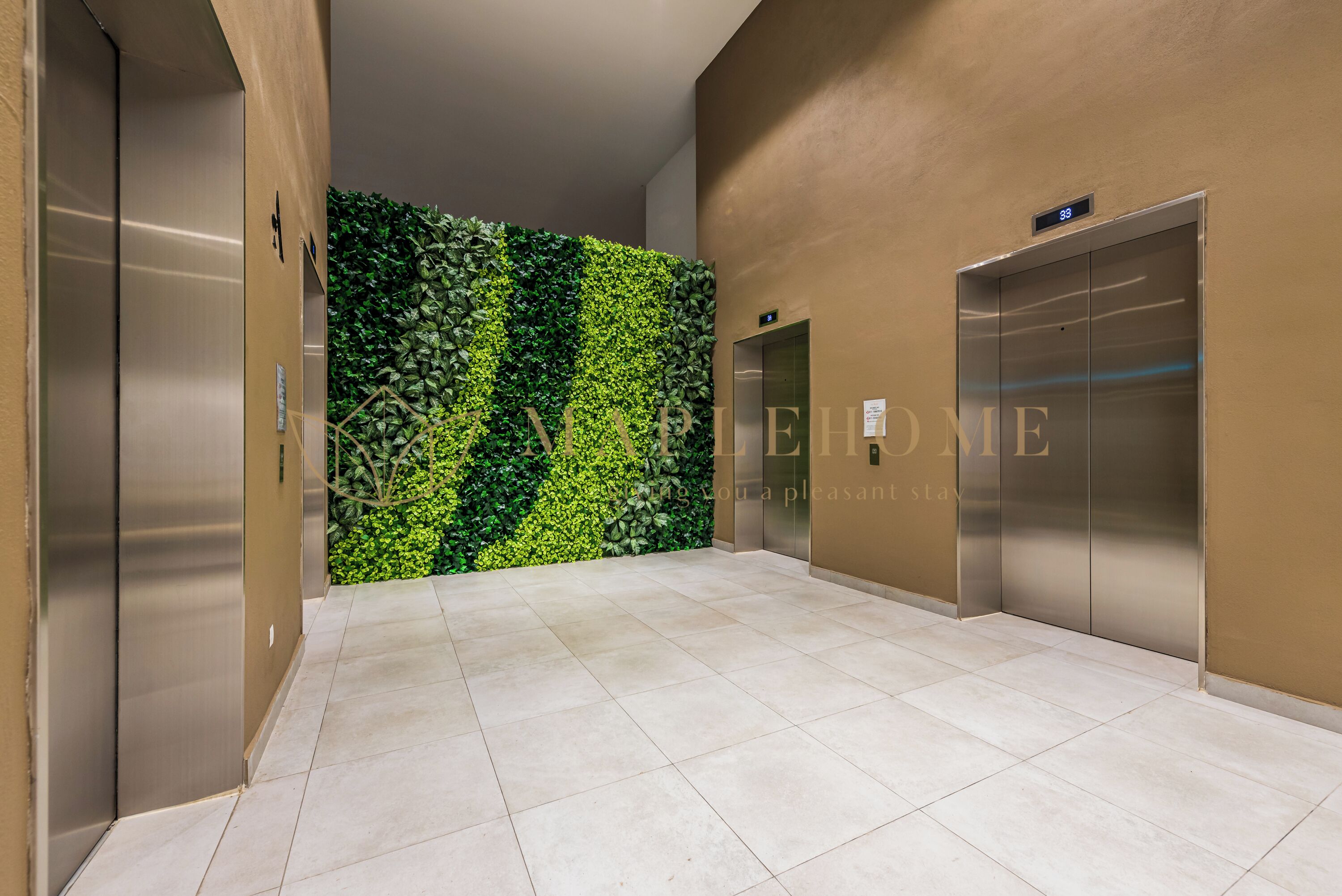A modern elevator area with a green wall and two elevators.