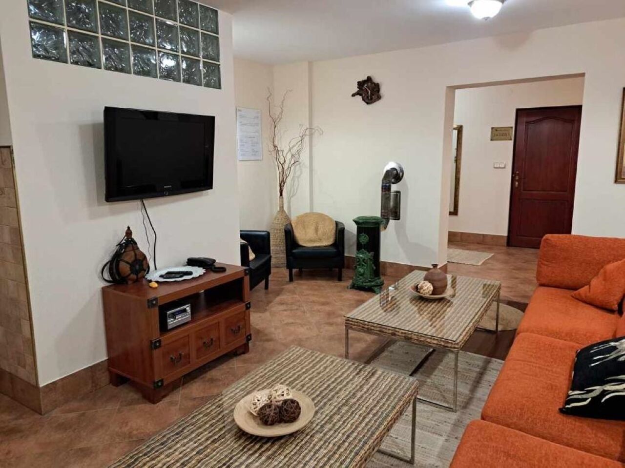 A living room with a TV, a sofa, a coffee table, and a cabinet.