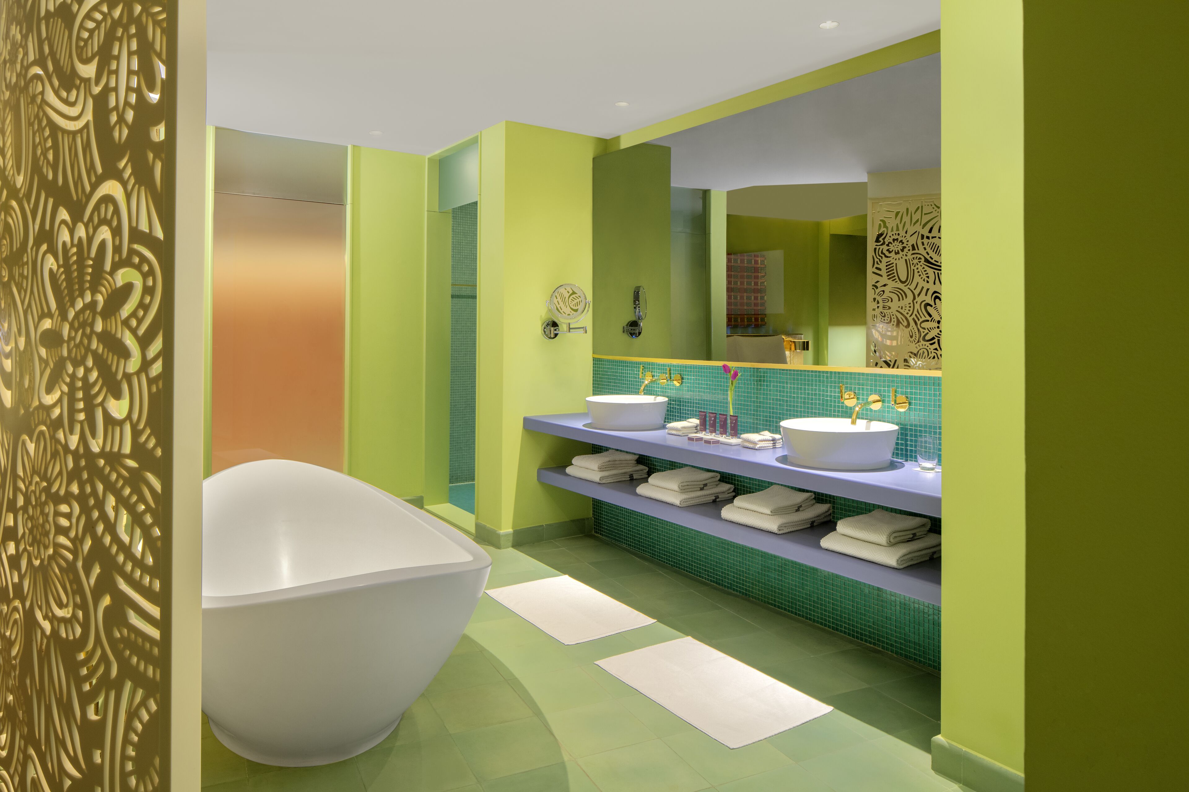 A modern bathroom with a freestanding bathtub, two sinks, and a large mirror.