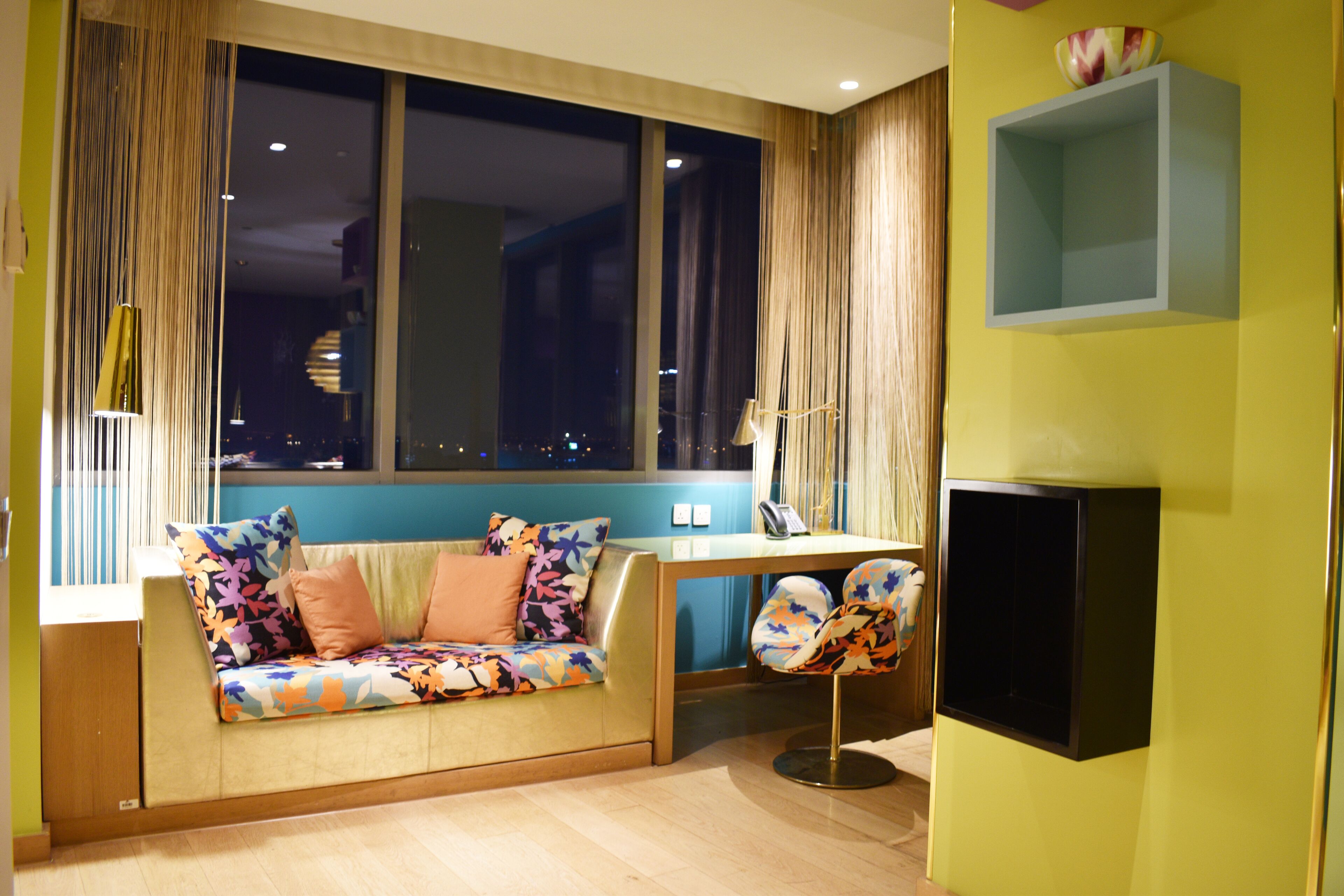 A modern living room with a sofa, a dining table, and a TV.
