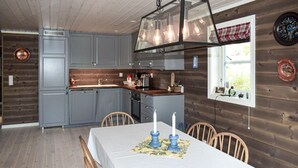 A kitchen with grey cabinets, a wooden countertop, and a hanging light fixture. - 4 bedroom pet friendly home in Eggedal (Eggedal)
