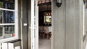A wooden door with a glass panel, a small table with chairs, and a hanging light fixture. - 4 bedroom pet friendly home in Eggedal (Eggedal)