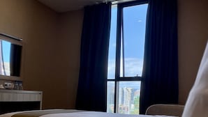 A hotel room with two beds, a desk with a mirror, and a window with curtains. - Betlem Hotel (Tbilisi)
