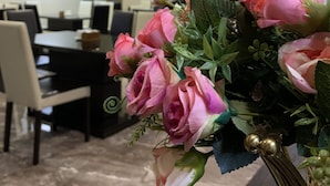 A conference room with a table and chairs, a floral arrangement on a table, and ceiling lights. - Betlem Hotel (Tbilisi)