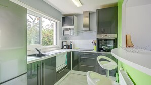 Una cocina moderna con horno empotrado, un lavamanos y una ventana.