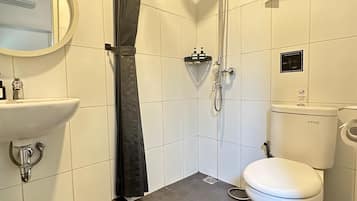A bathroom with a shower, toilet, sink, and a towel rack.