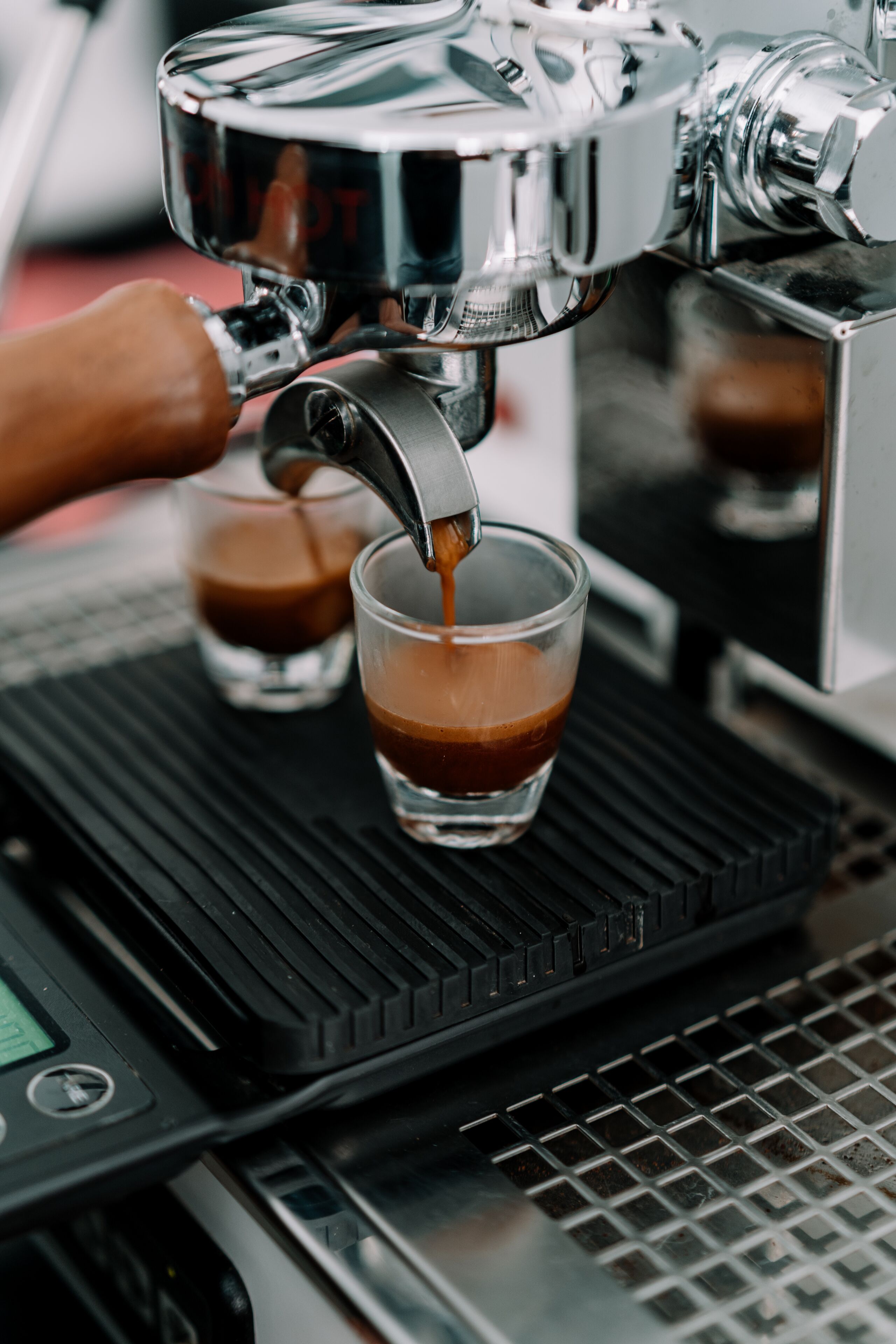 A coffee machine dispensing espresso into a cup.
