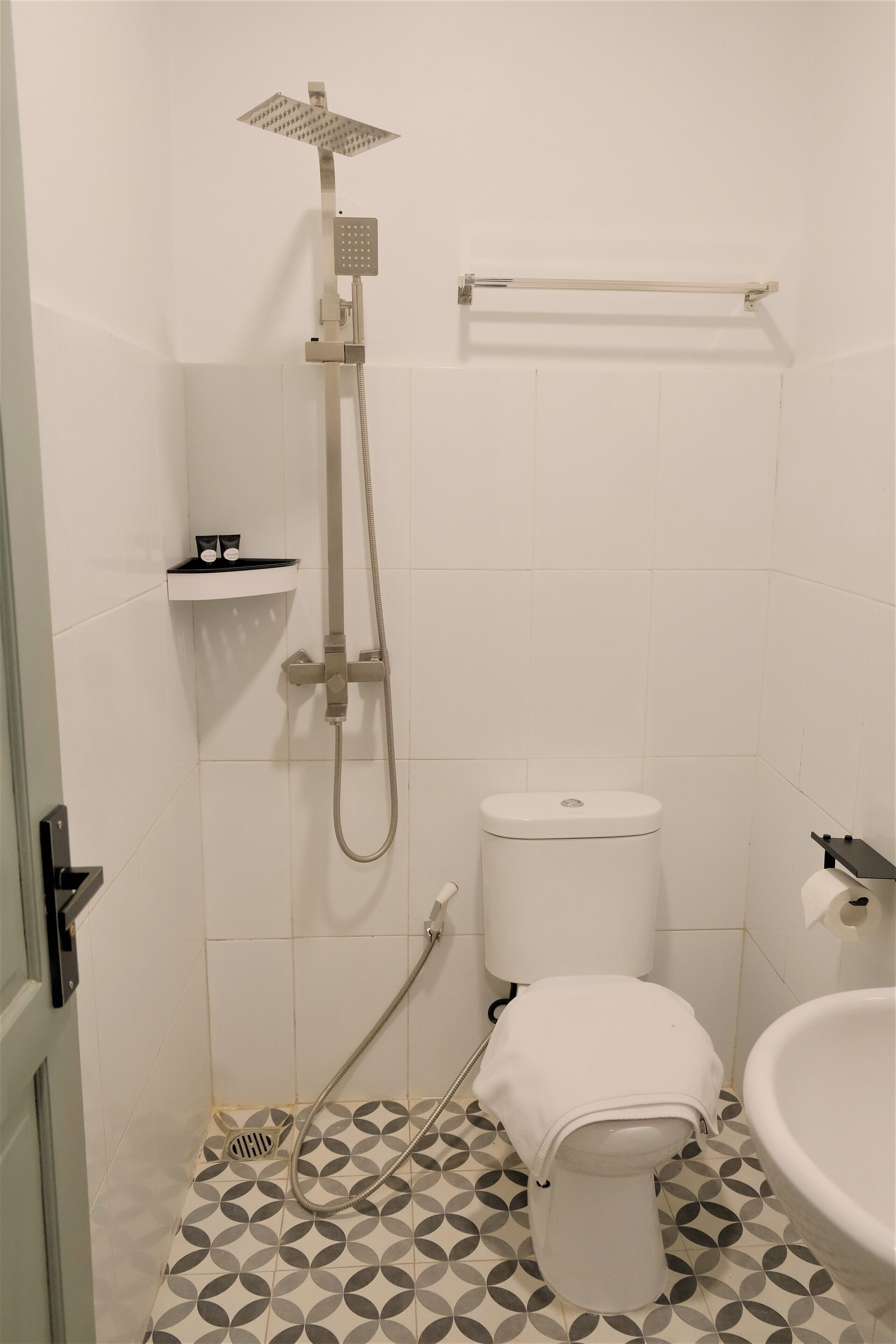 A small bathroom with a toilet, a sink, and a shower.