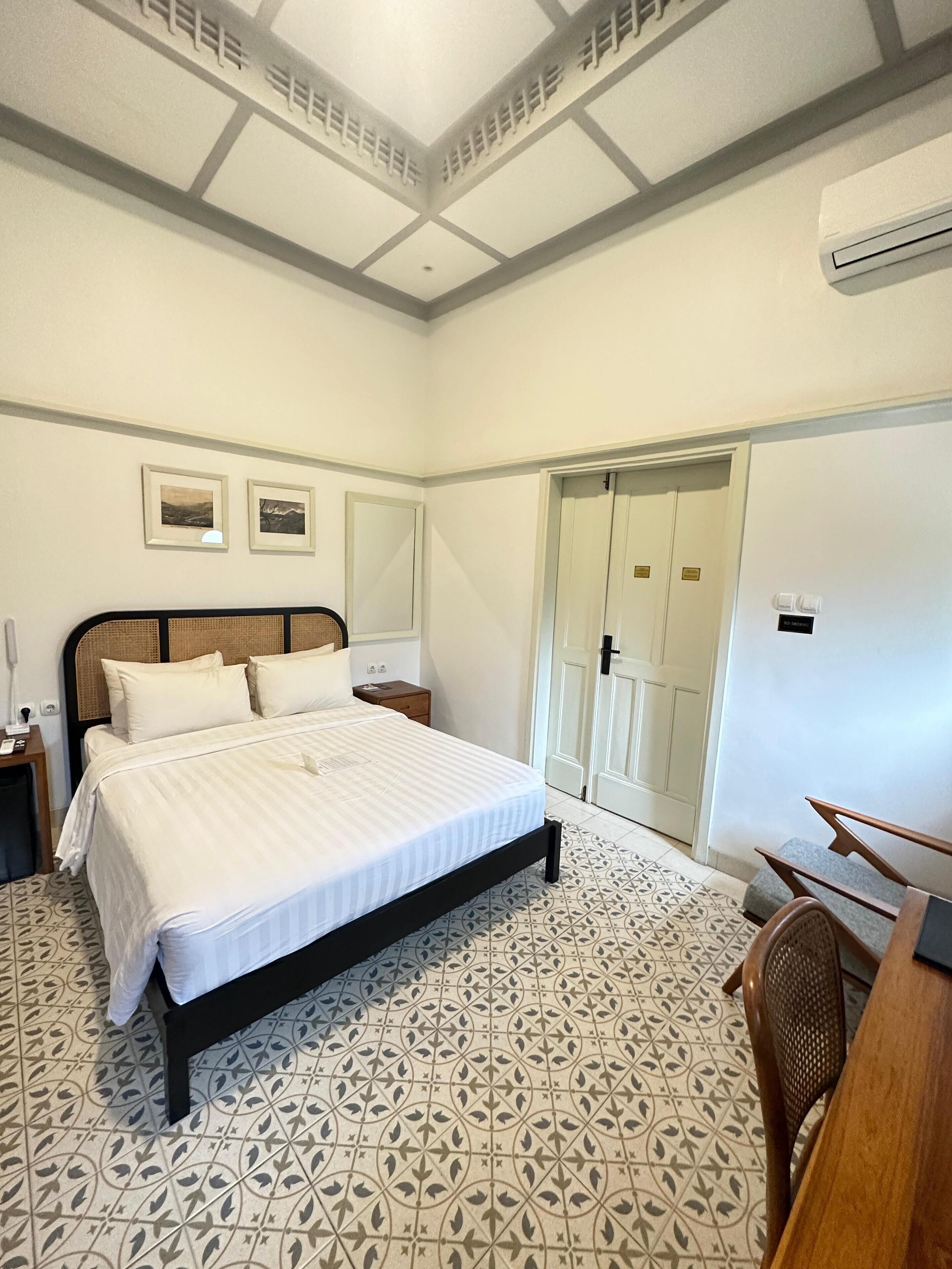 Ein Schlafzimmer mit Bett, Nachttischen, Schreibtisch und Kleiderschrank.
