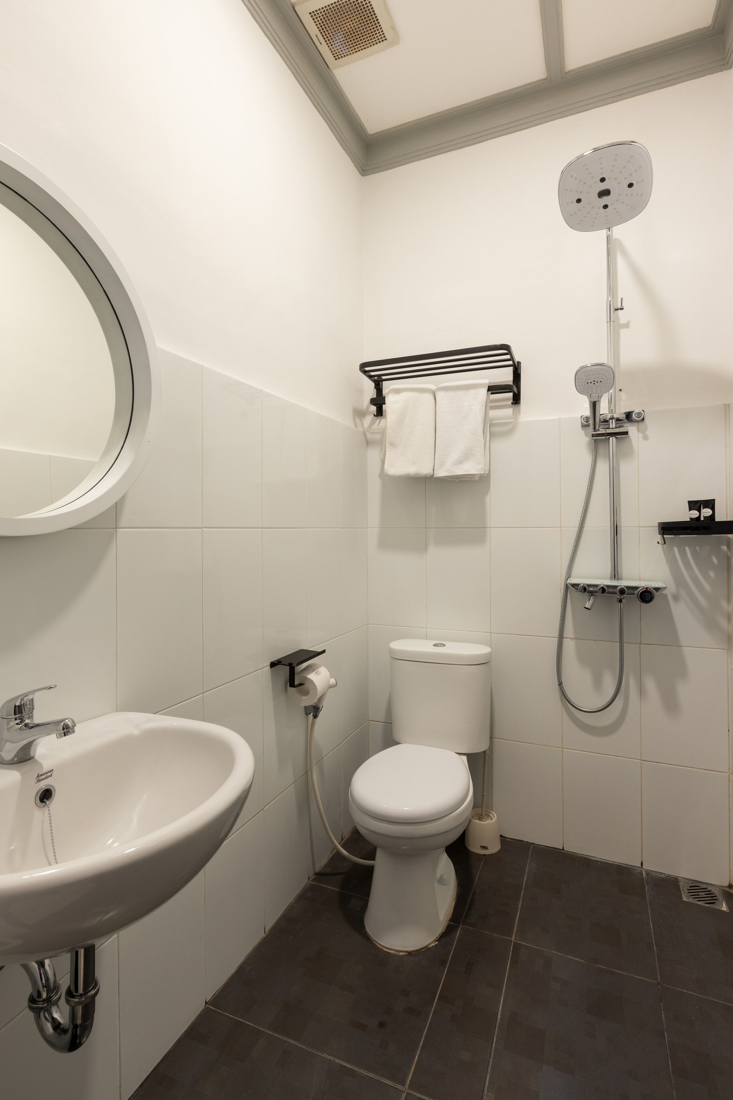 A bathroom with a white sink, toilet, and shower.
