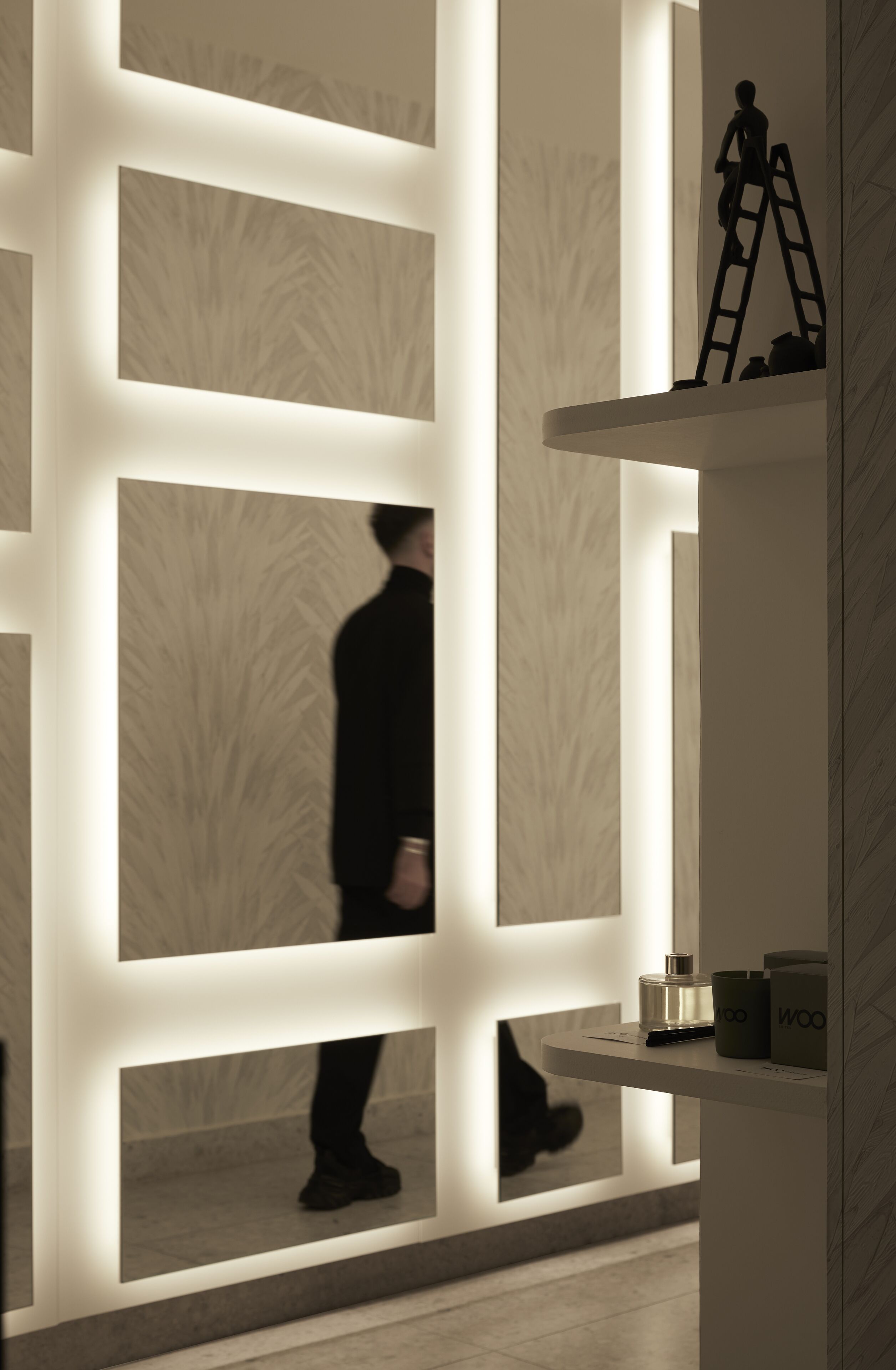 Een modern interieur met een persoon die langs verlichte panelen loopt.
