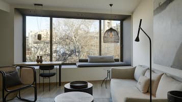 Una sala de estar moderna con un ventanal grande, un sofá, una mesa de comedor y una lámpara colgante.