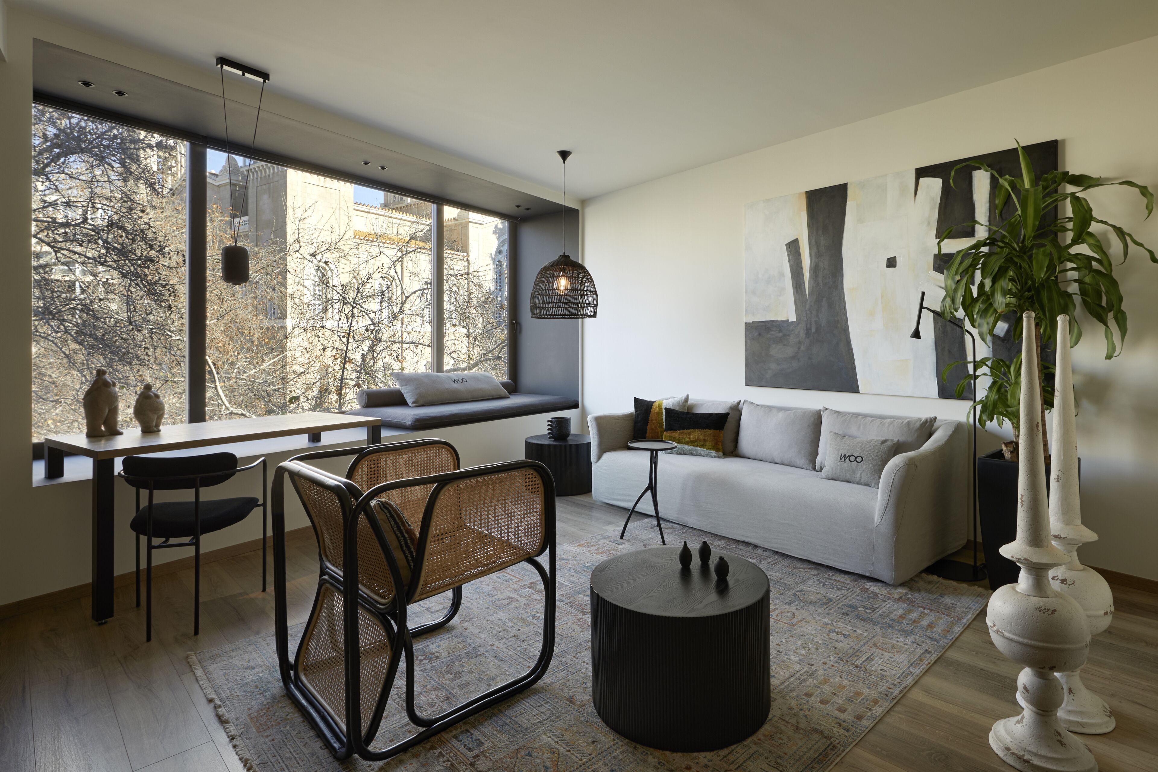 Un salon moderne avec une grande fenêtre, un canapé, une table à manger et une table basse.