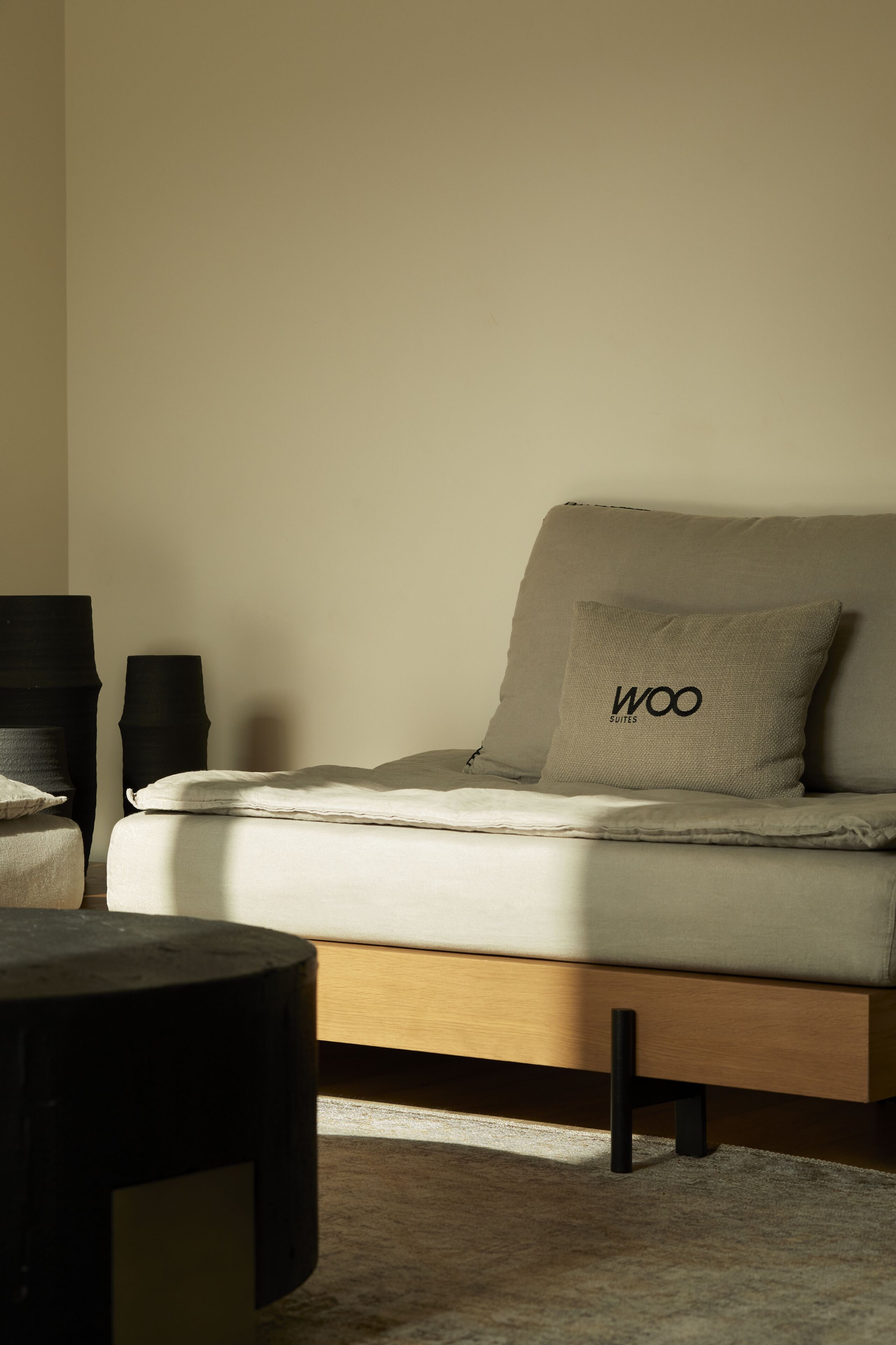 Un dormitorio minimalista con una cama, una mesita de noche y una lámpara.