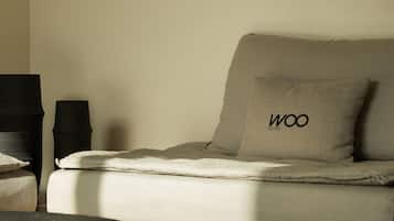 Un dormitorio minimalista con una cama, una mesita de noche y una lámpara.