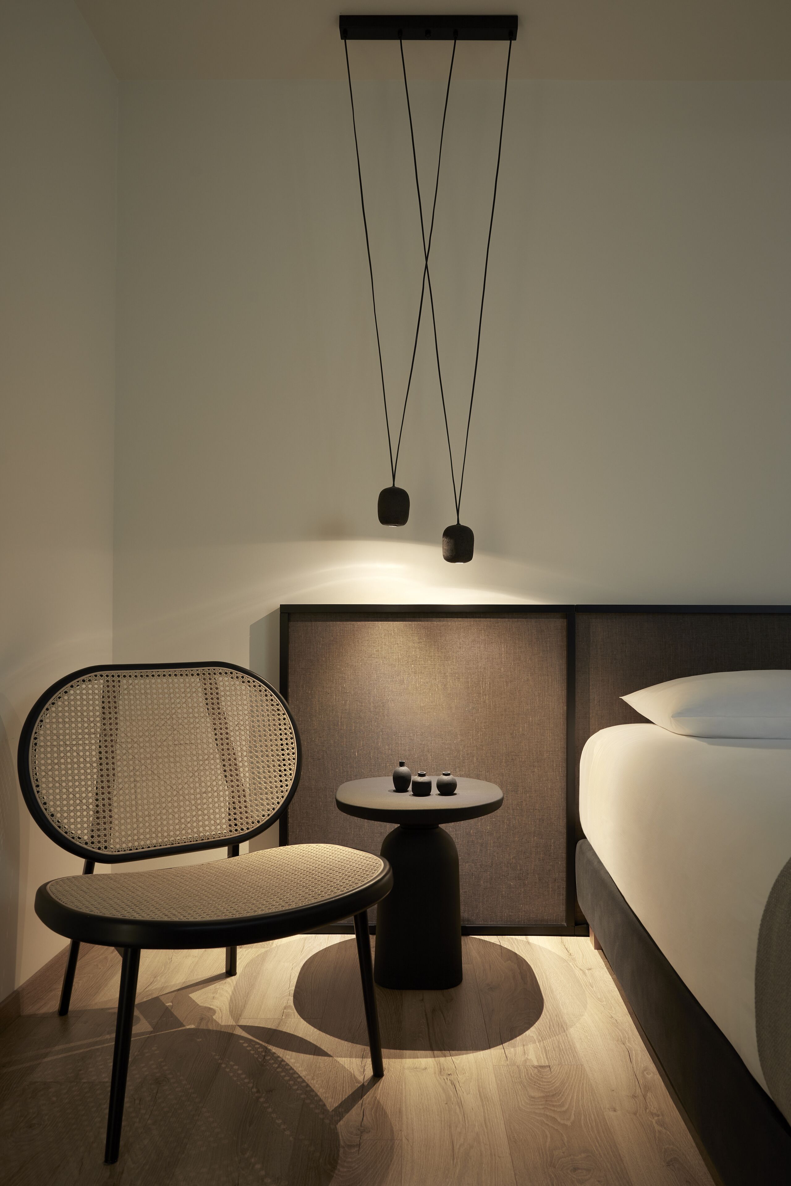 A modern hotel room with a bed, a round table, and a chair.