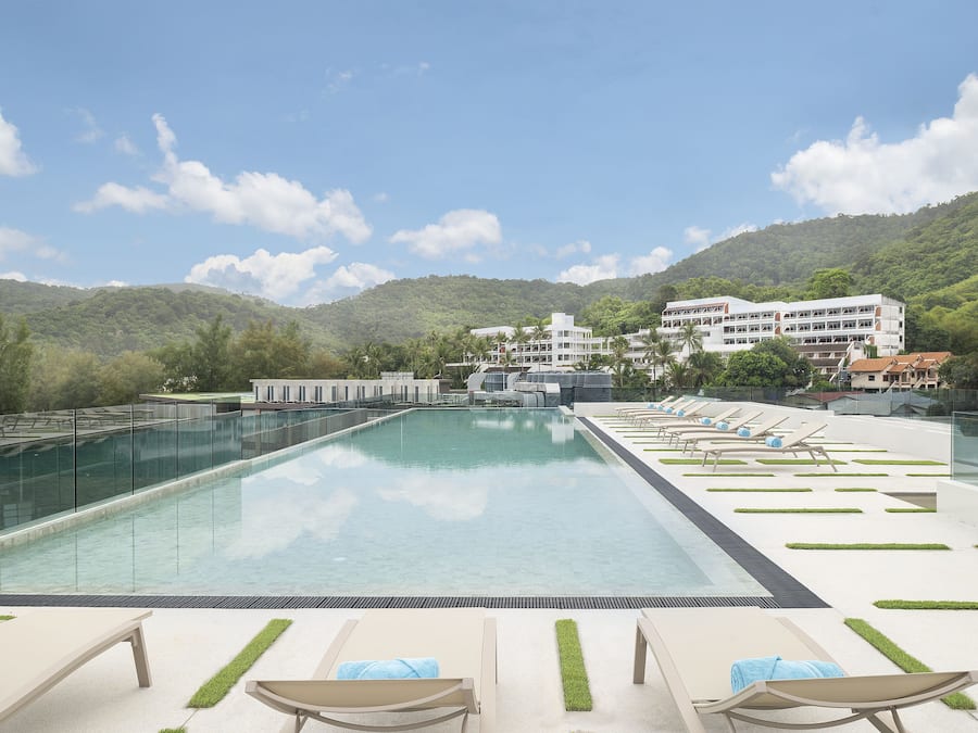 Una piscina al aire libre, sillones reclinables de piscina