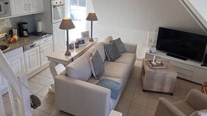 Un apartamento moderno con kitchenette, sofá, televisor y comedor.