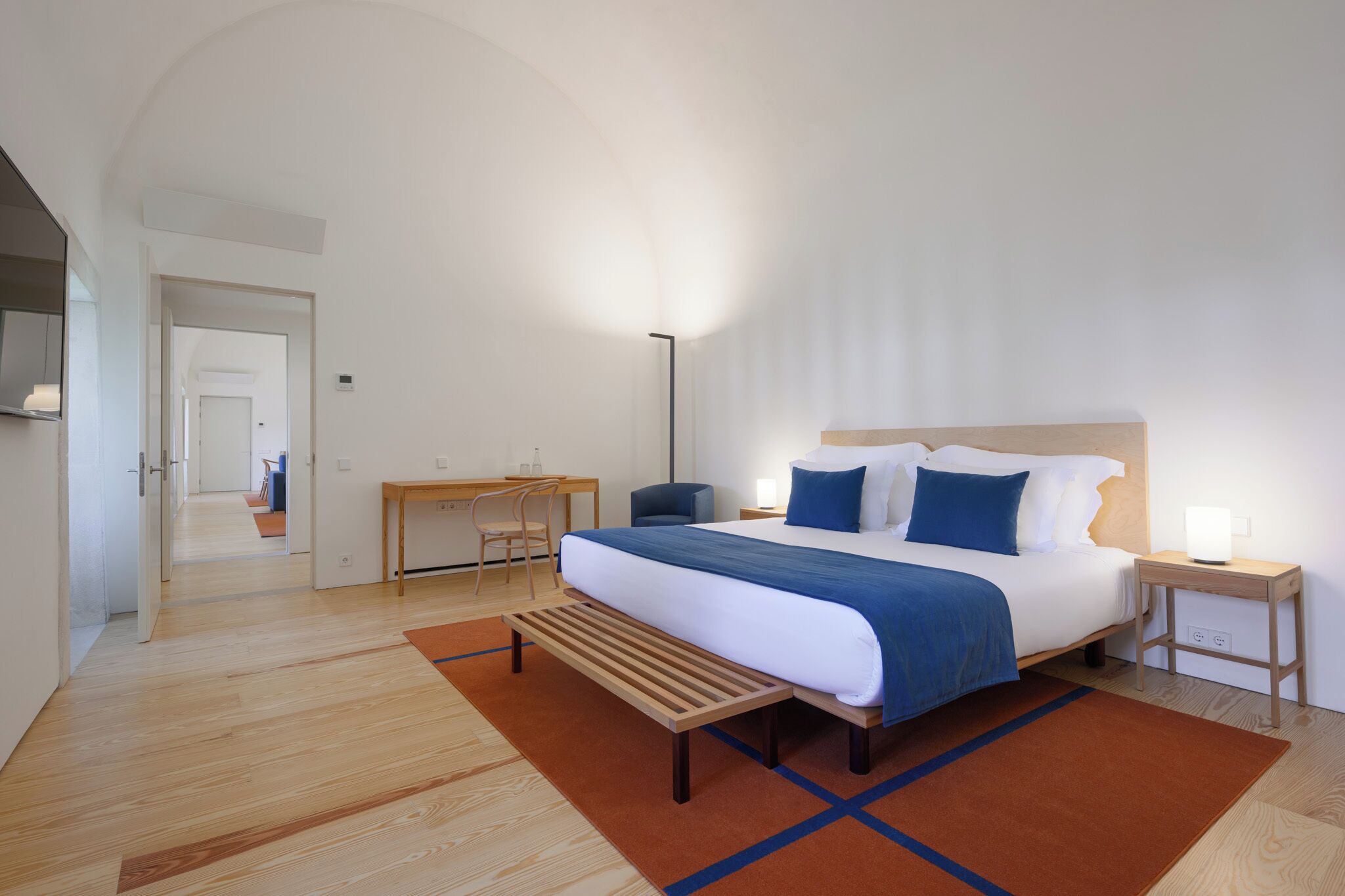 Une chambre d’hôtel moderne, dotée d’un grand lit, d’un bureau et d’une chaise.