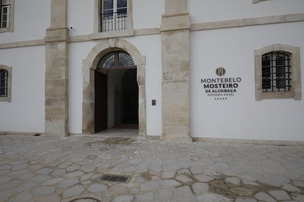 The entrance to Montebello Mosteiro de Alcobaça historic hotel with a cobblestone courtyard. - Montebelo Mosteiro de Alcobaça Historic Hotel (Alcobaça)