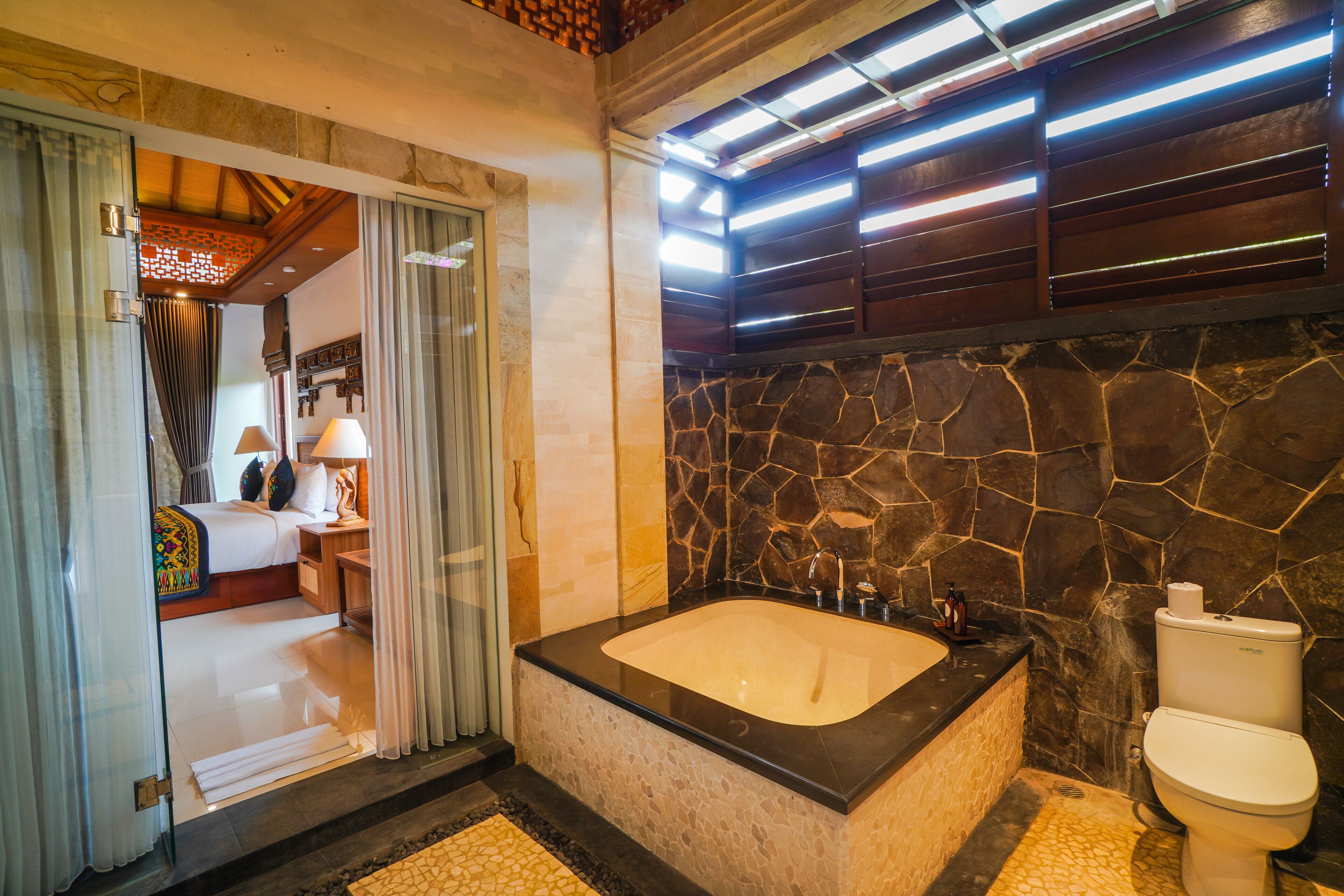 A bathroom with a large bathtub, a toilet, and a shower area.