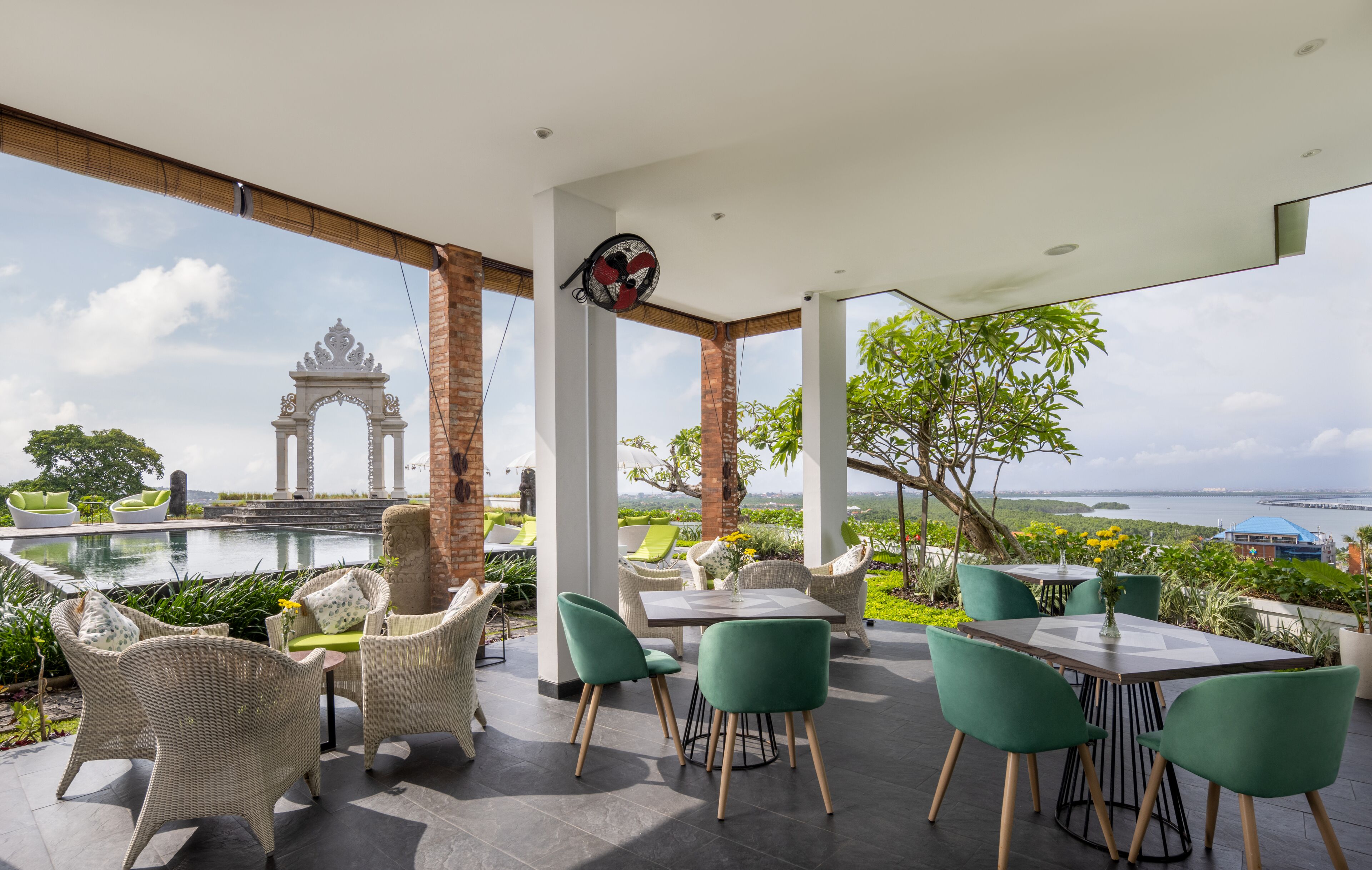 An outdoor patio with wicker furniture and a view of a historic archway.