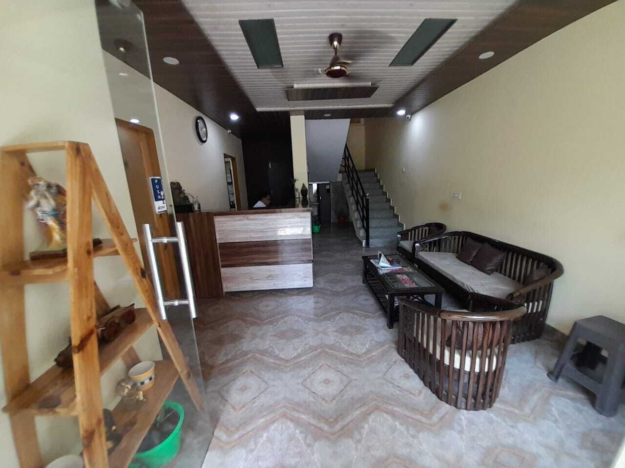 A reception area with a desk, seating, and a staircase leading to an upper floor.