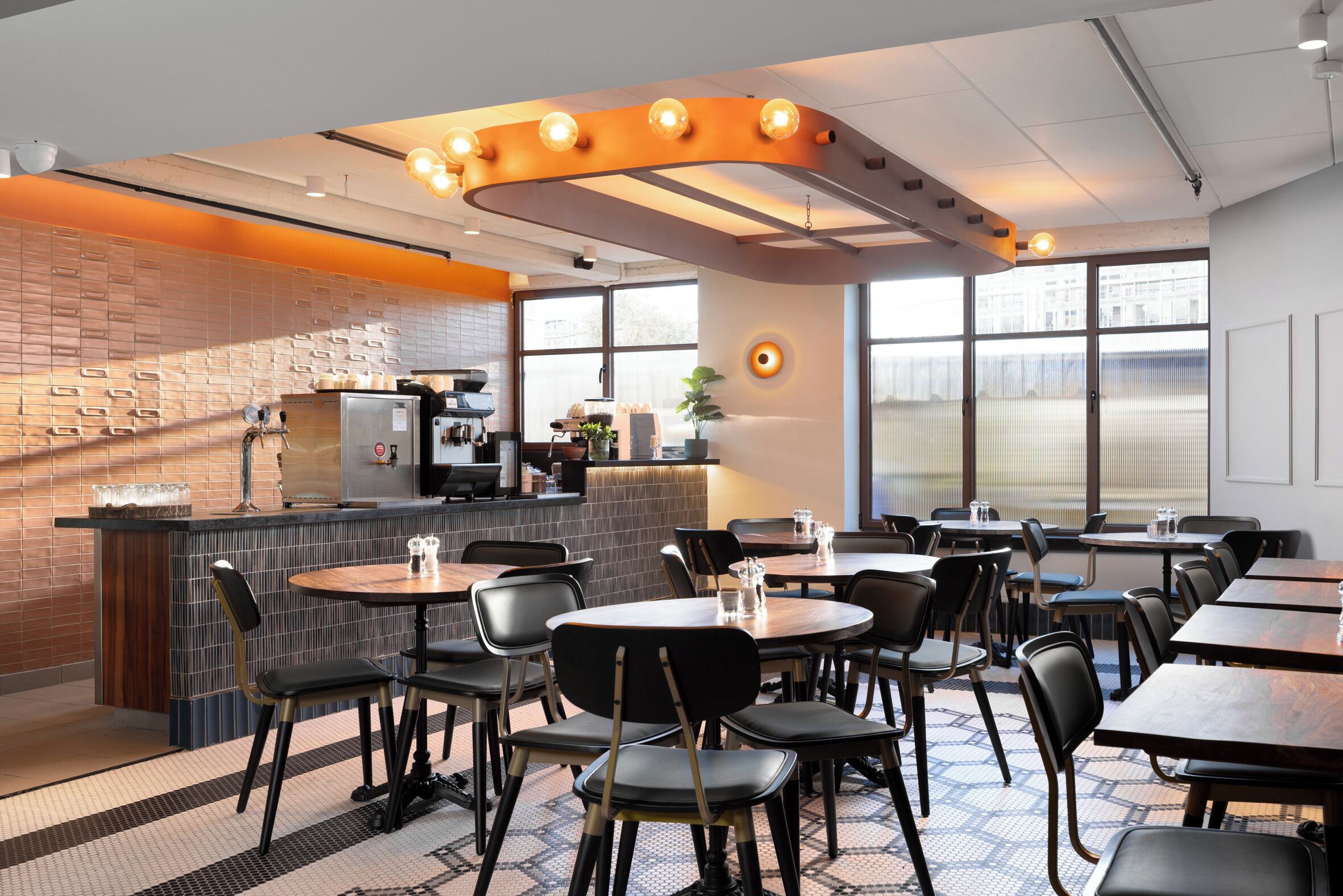 A modern restaurant with a brick wall, a bar area, and large windows.