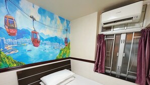 A hotel room with a bed, a mural of a cityscape with cable cars, an air conditioning unit, and a window with curtains. - National Inn HK (Kowloon)