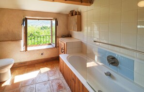 Enjoy a relaxing soak in the spacious bathtub with a scenic view.