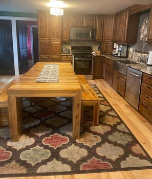 A kitchen with wooden cabinets, a stainless steel refrigerator, a microwave, and a stove.