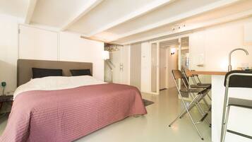 Une chambre d’hôtel moderne, équipée d’un lit, d’un bureau et d’une chaise.