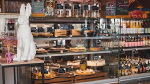 A bakery display with various baked goods and a menu board above. - H11 Aparthotel (Kraków)