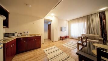 Apartament estàndard, diversos llits | Cuina privada | Cafetera i tetera, bullidora elèctrica i una taula de menjador