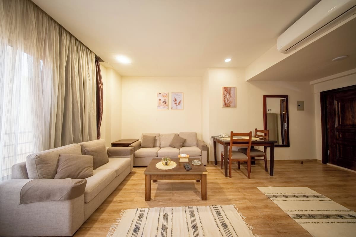A living room with a sofa, coffee table, and dining area.