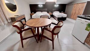 A modern hotel room with a dining area, two beds, a compact kitchenette, and a skylight. - Elit Otel (Antalya)