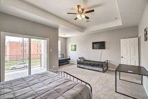 A bedroom with a bed, a desk, a ceiling fan, and a TV on the wall. - Brand New Double Story Home ~ Pet Friendly (Houston)