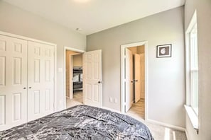 A bedroom with a bed, white double doors, a hallway, and a small framed picture on the wall. - Brand New Double Story Home ~ Pet Friendly (Houston)