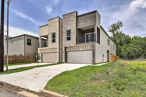 A modern two-story house with a garage, a stone facade, and a small front yard. - Brand New Double Story Home ~ Pet Friendly (Houston)