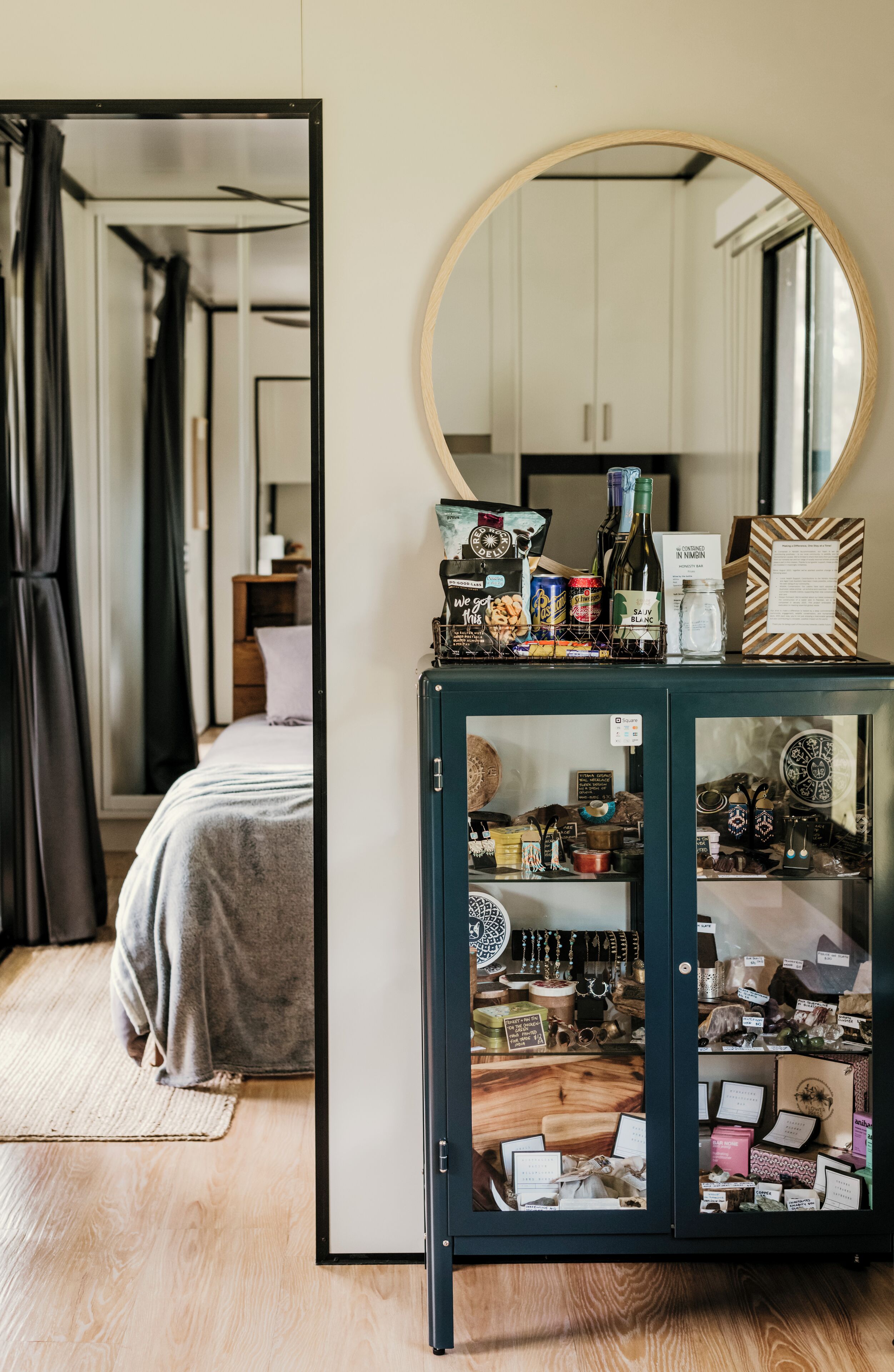 Une pièce comprenant un lit, un miroir et une armoire contenant divers objets.
