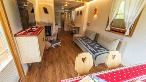 A cozy interior with a wooden floor, a sofa, a small table, and a cabinet.